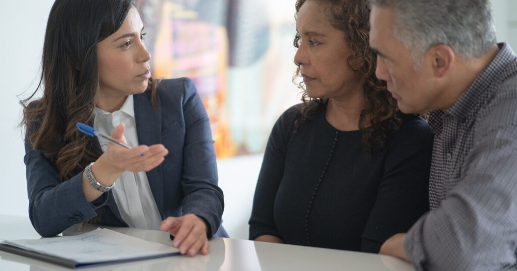 female attorney talking to a couple about their legal claim